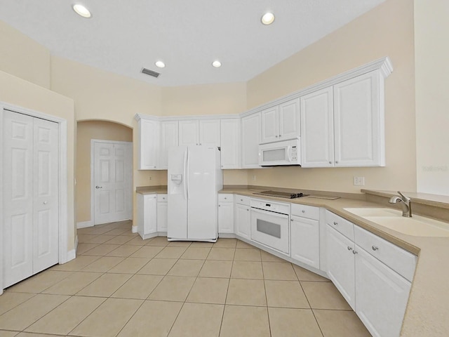 kitchen with sink, white appliances, white cabinets, and light tile patterned floors