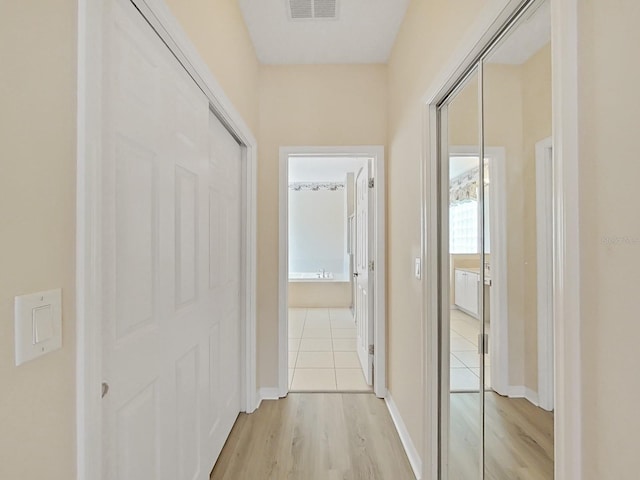 hallway with light hardwood / wood-style floors