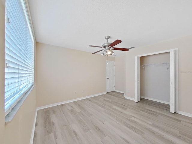 unfurnished bedroom with ceiling fan, light wood-type flooring, and a closet