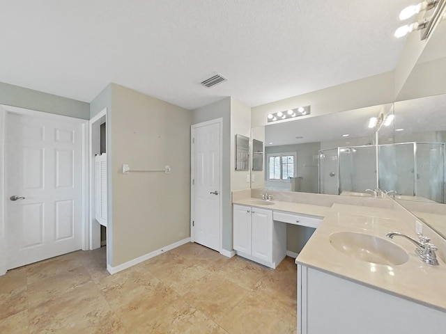 bathroom with vanity and a shower with door