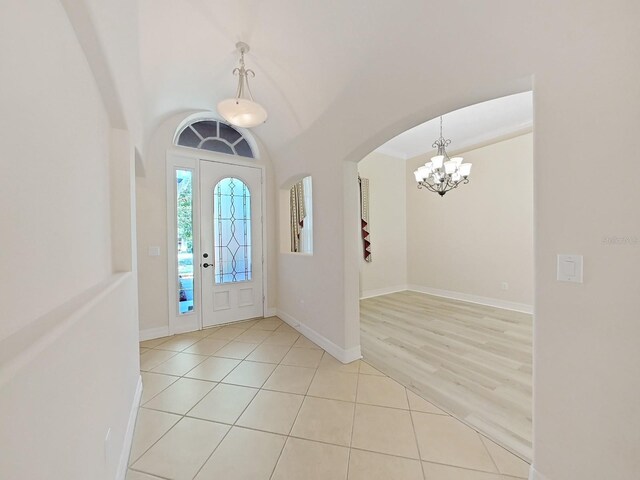 foyer entrance featuring light tile patterned flooring and a notable chandelier