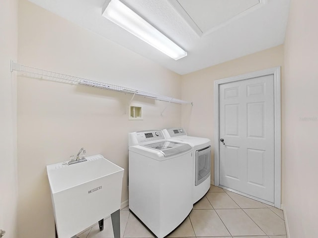 laundry room with light tile patterned floors, sink, and separate washer and dryer