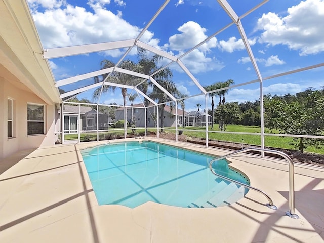 view of pool with a patio and glass enclosure