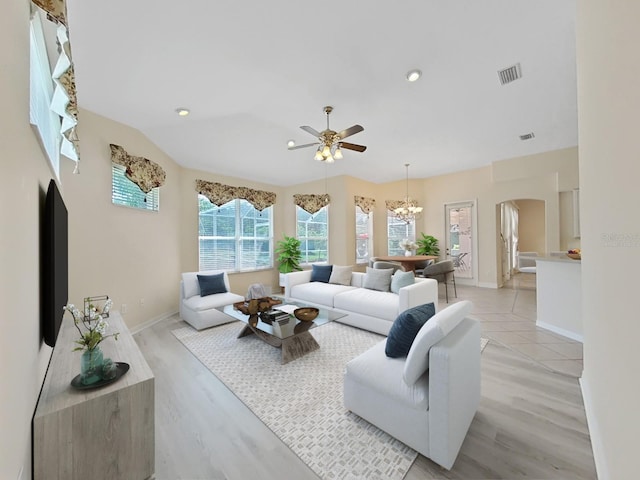 living room featuring ceiling fan with notable chandelier and light hardwood / wood-style floors