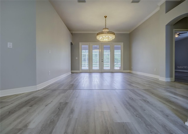 19334 Autumn Woods Ave, Tampa, FL 33647 - unfurnished dining area featuring an inviting chandelier, wood finished floors, baseboards, french doors, and arched walkways