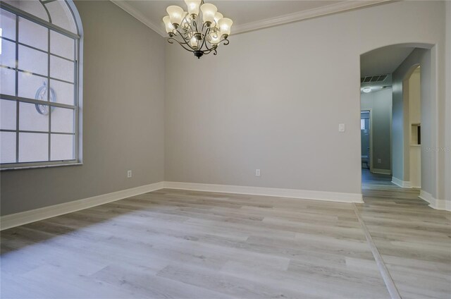 19334 Autumn Woods Ave, Tampa, FL 33647 - spare room with crown molding, arched walkways, light wood finished floors, and a notable chandelier