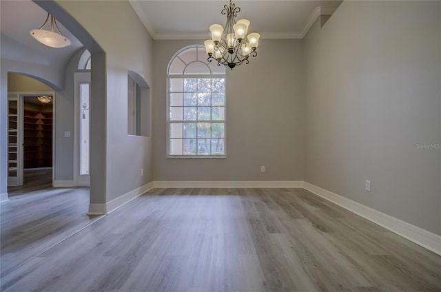 19334 Autumn Woods Ave, Tampa, FL 33647 - unfurnished dining area with crown molding, arched walkways, wood finished floors, baseboards, and an inviting chandelier