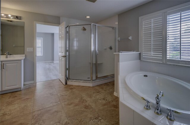 19334 Autumn Woods Ave, Tampa, FL 33647 - full bathroom with vanity, a healthy amount of sunlight, a bath, and a stall shower