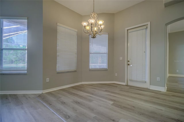 19334 Autumn Woods Ave, Tampa, FL 33647 - unfurnished dining area featuring a notable chandelier, plenty of natural light, and wood finished floors