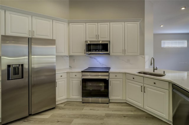 19334 Autumn Woods Ave, Tampa, FL 33647 - kitchen featuring appliances with stainless steel finishes, a sink, light wood finished floors, light countertops, and white cabinetry