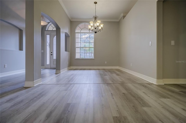19334 Autumn Woods Ave, Tampa, FL 33647 - unfurnished dining area featuring ornamental molding, wood finished floors, baseboards, a chandelier, and arched walkways