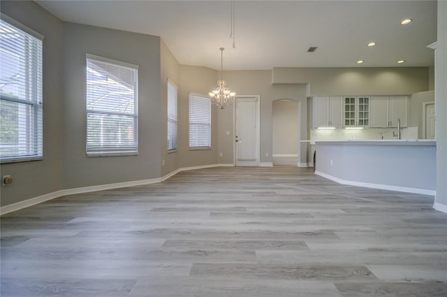 19334 Autumn Woods Ave, Tampa, FL 33647 - interior space with an inviting chandelier, arched walkways, light wood finished floors, and visible vents