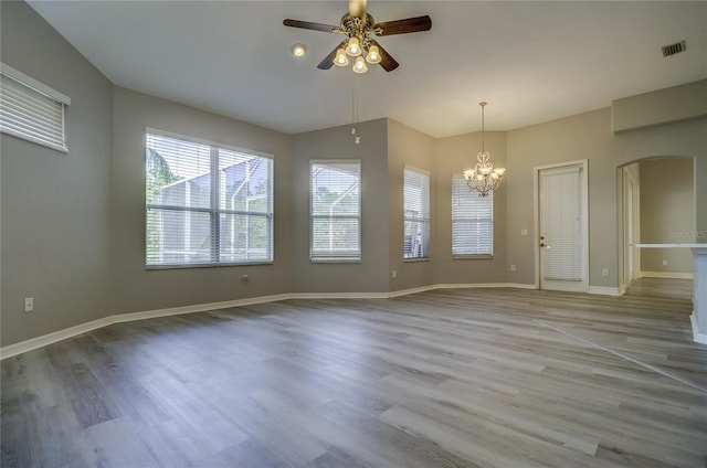 19334 Autumn Woods Ave, Tampa, FL 33647 - interior space featuring arched walkways, ceiling fan with notable chandelier, baseboards, wood finished floors, and visible vents