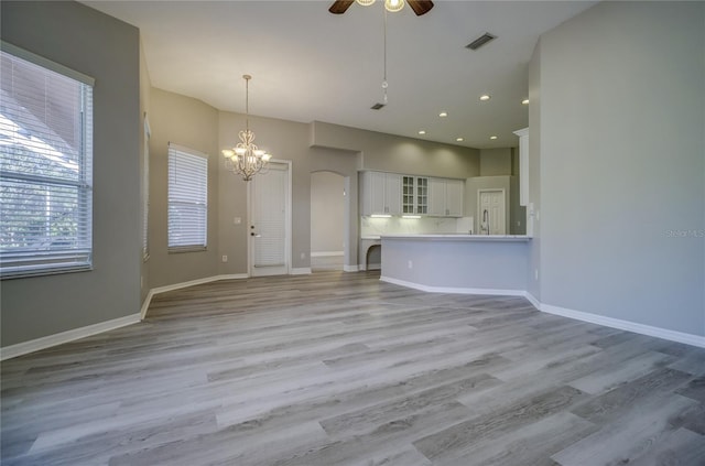 19334 Autumn Woods Ave, Tampa, FL 33647 - unfurnished living room with baseboards, visible vents, ceiling fan with notable chandelier, and light wood-style floors