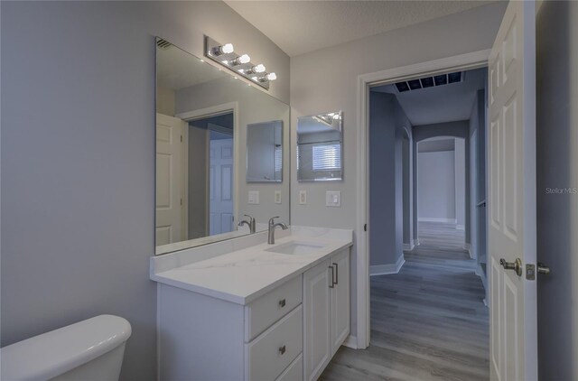 19334 Autumn Woods Ave, Tampa, FL 33647 - bathroom featuring visible vents, vanity, wood finished floors, toilet, and baseboards