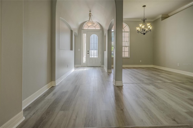 19334 Autumn Woods Ave, Tampa, FL 33647 - foyer entrance with crown molding, wood finished floors, baseboards, arched walkways, and a notable chandelier