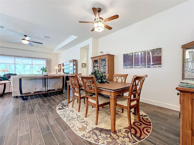 dining space with a tray ceiling and ceiling fan