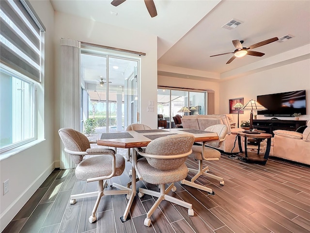 dining room with ceiling fan and a tray ceiling