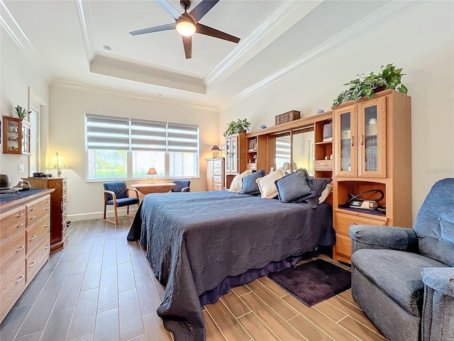 bedroom featuring crown molding, ceiling fan, and a tray ceiling