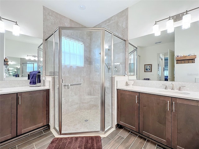 bathroom featuring vanity and a shower with door