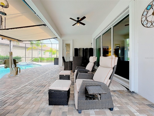 view of patio featuring ceiling fan and glass enclosure