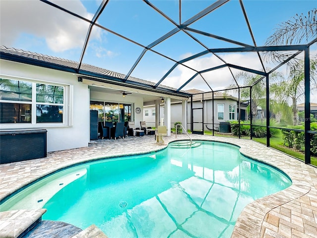 view of swimming pool with a patio, a lanai, ceiling fan, and central air condition unit