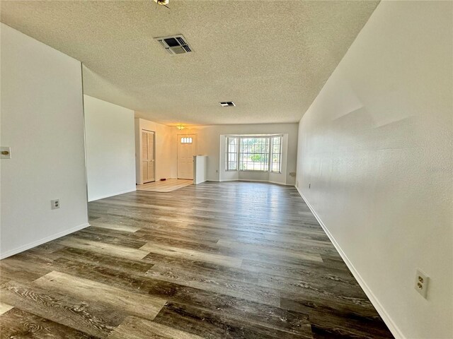 spare room featuring wood-type flooring and a textured ceiling