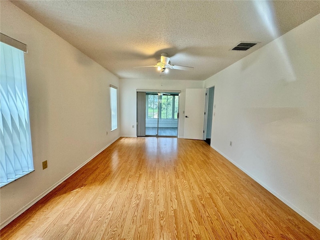 spare room featuring a textured ceiling, light wood-type flooring, and ceiling fan