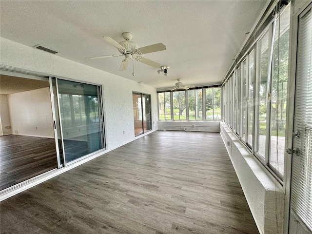 unfurnished sunroom featuring ceiling fan