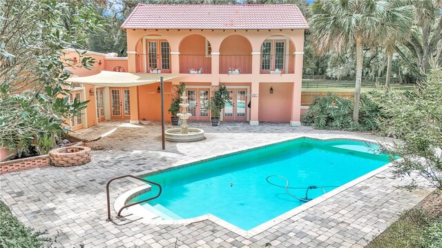 view of swimming pool with a patio and french doors