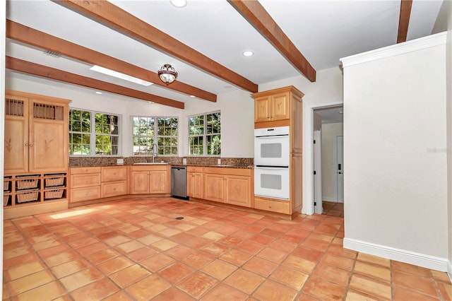 kitchen featuring sink, dishwasher, beam ceiling, double oven, and light tile patterned floors