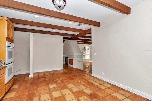 interior space featuring beamed ceiling, ornate columns, and light tile patterned floors