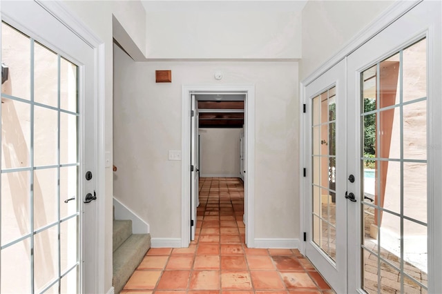 entrance foyer featuring french doors, a healthy amount of sunlight, and light tile patterned floors