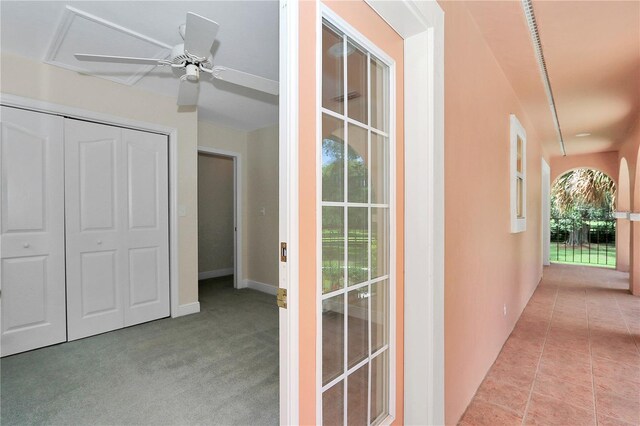 hallway with light colored carpet and plenty of natural light