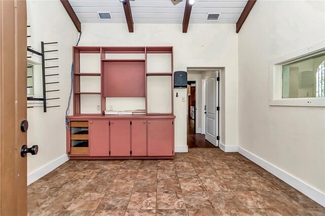 unfurnished bedroom with vaulted ceiling with beams and tile patterned floors