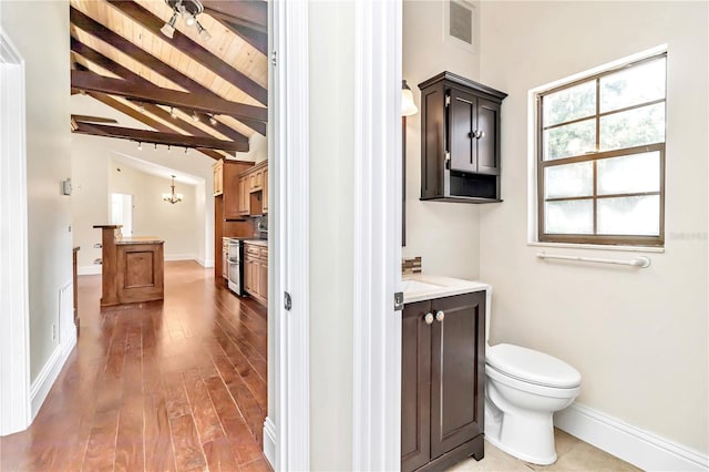 bathroom featuring vanity, hardwood / wood-style flooring, wooden ceiling, beam ceiling, and toilet