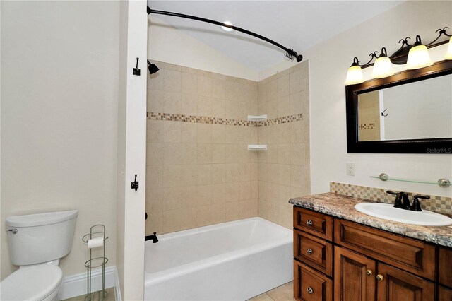 full bathroom featuring vanity, tiled shower / bath, tile patterned flooring, and toilet