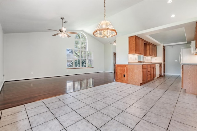 kitchen with vaulted ceiling, light tile patterned flooring, sink, ceiling fan, and white appliances