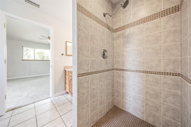 bathroom with vanity, ceiling fan, tile patterned flooring, and tiled shower