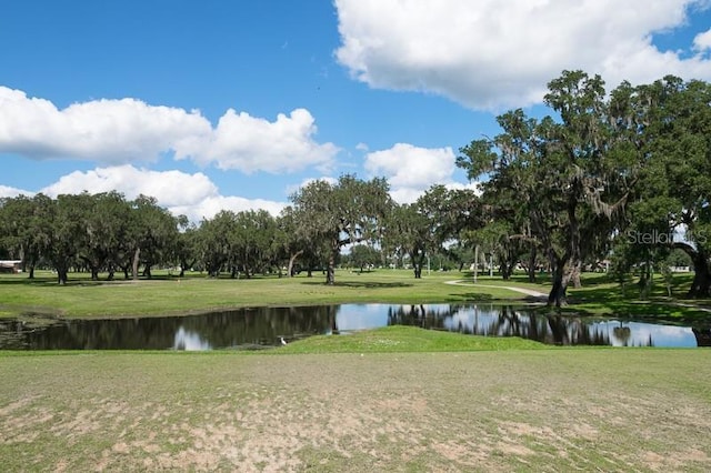 surrounding community with a water view and a yard