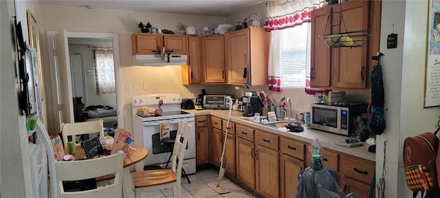 kitchen featuring sink, light tile patterned floors, a textured ceiling, and electric range