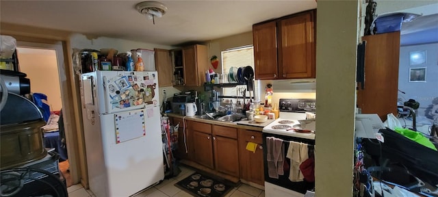 kitchen featuring sink, light tile patterned floors, and white appliances