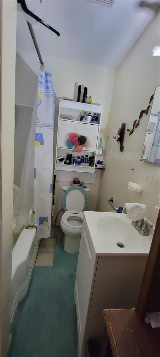 full bathroom featuring vanity, shower / bathtub combination with curtain, and toilet