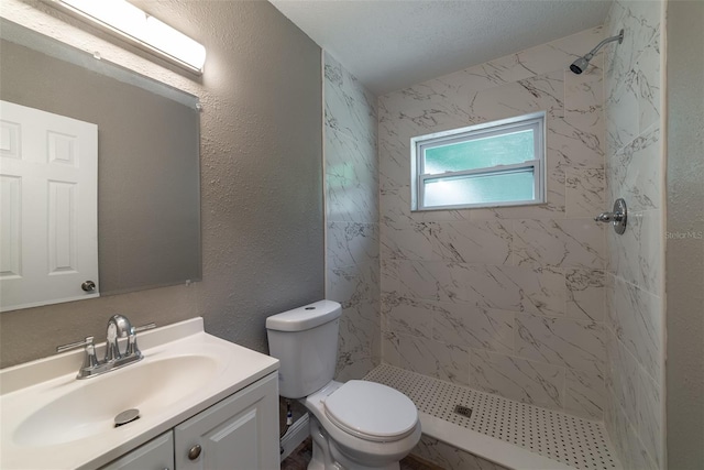 bathroom featuring vanity, tiled shower, and toilet