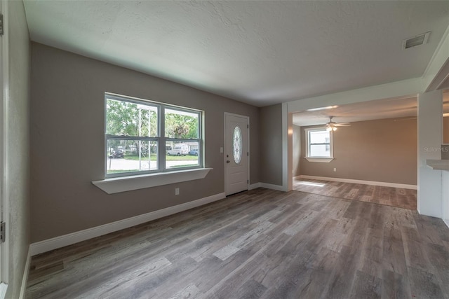 foyer featuring ceiling fan, a textured ceiling, and light wood-type flooring