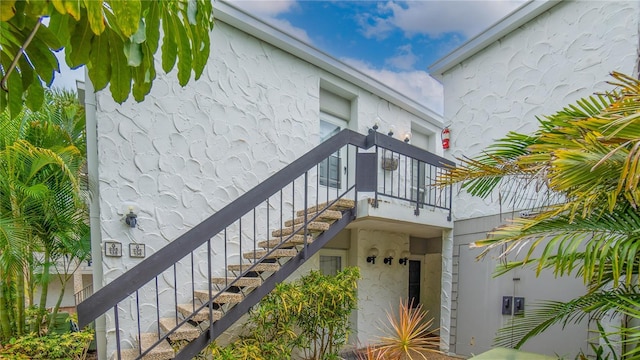 exterior space featuring stairway and stucco siding