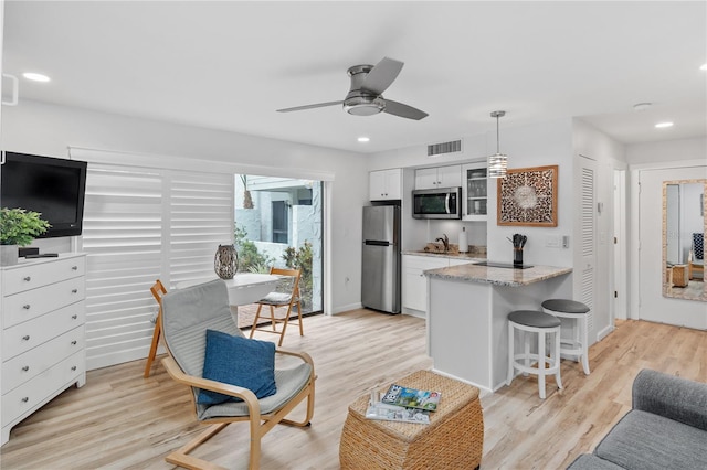 living room featuring light hardwood / wood-style floors, sink, and ceiling fan