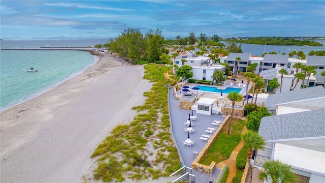 birds eye view of property with a water view and a beach view