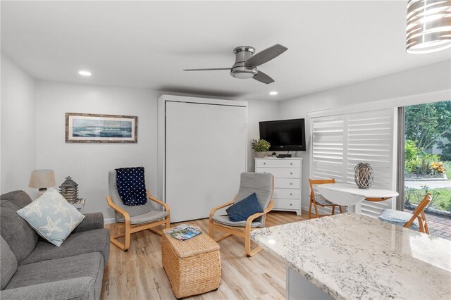 living room with ceiling fan and light wood-type flooring