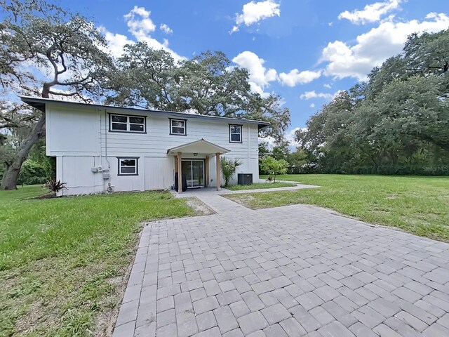 view of front facade with central AC unit and a front lawn